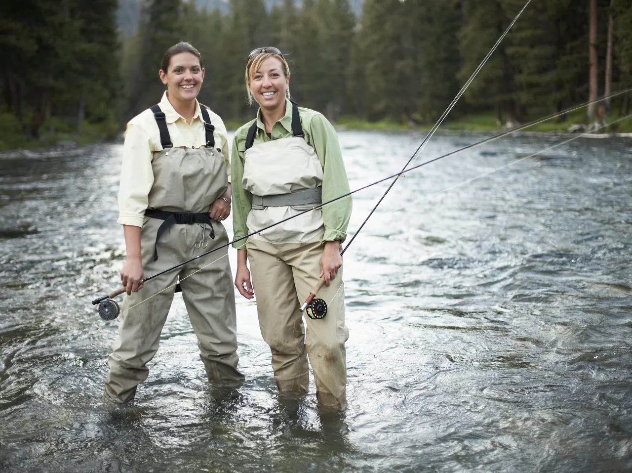Zwei Angler in Wathosen stehen im Fluss