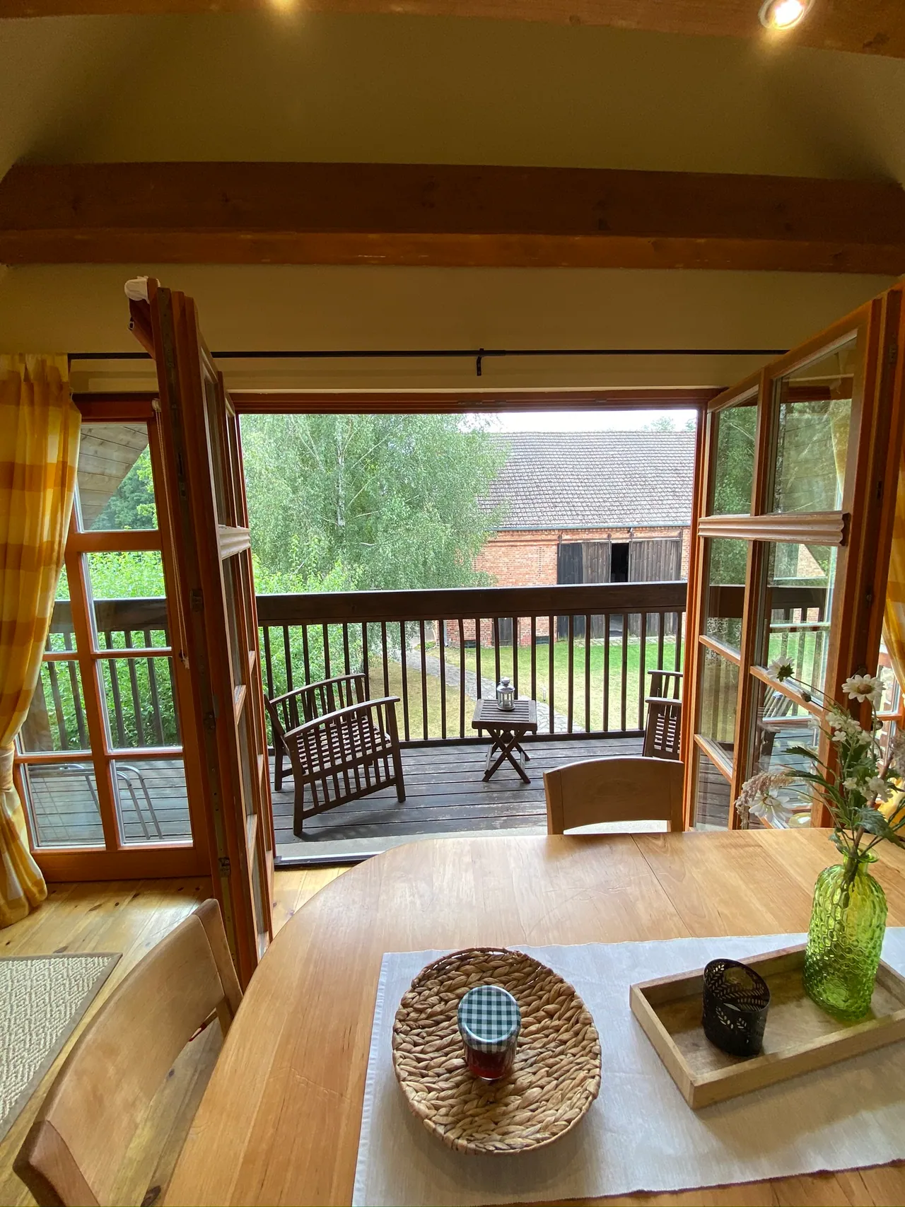Ferienwohnung I: Blick vom Esstisch durch die Balkontür auf den überdachten Balkon