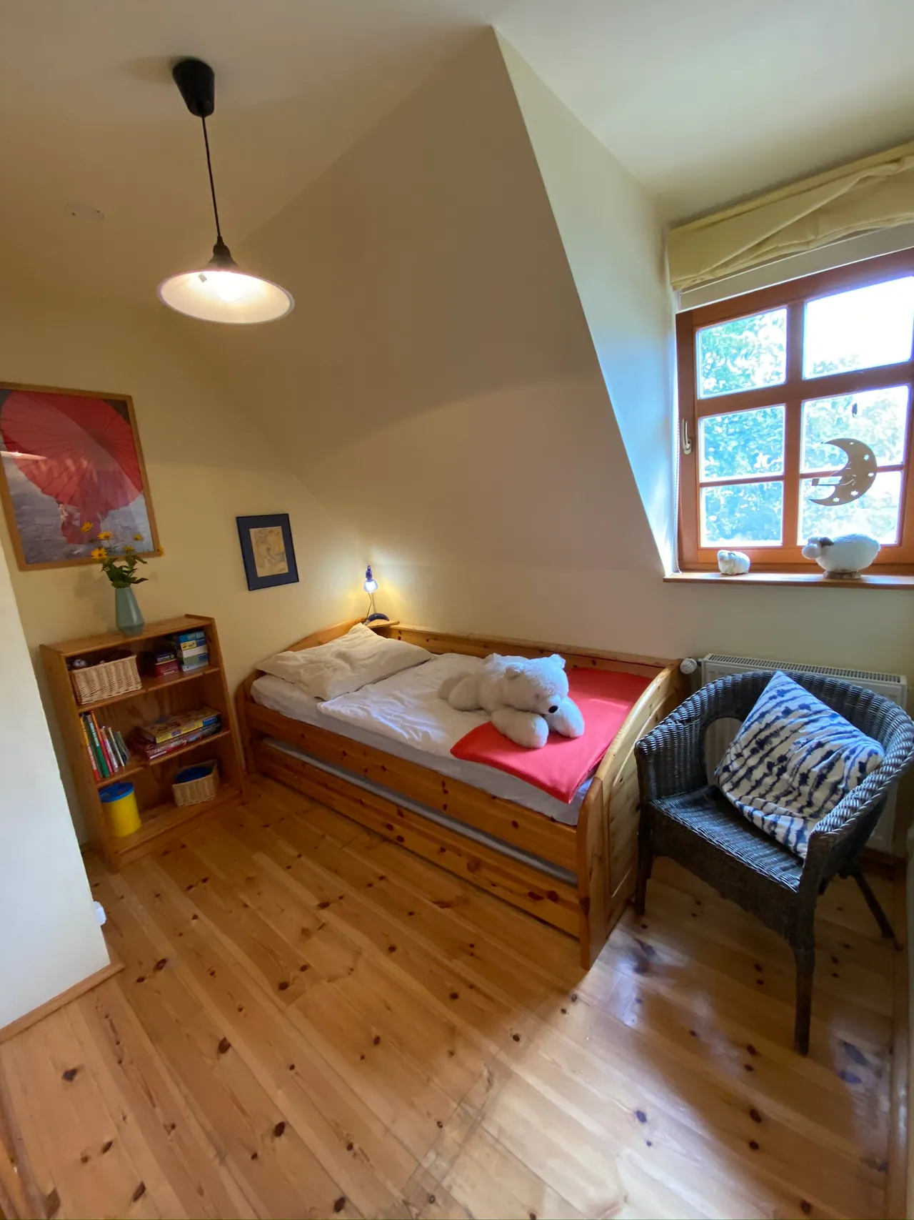 Ferienwohnung I: Kinderzimmer mit Dachschräge, Korbsessel und Fenster ins Grüne