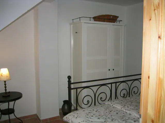 Ferienwohnung II: Schlafzimmer mit Metallbett und hellem Kleiderschrank