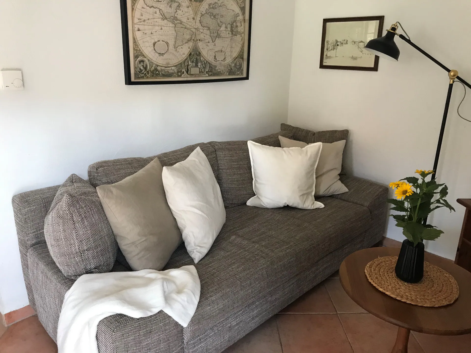 Ferienwohnung II: Schlafsofa mit Kissen vor historischer Landkarte