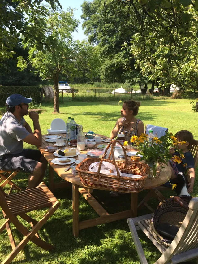 Gedeckter Frühstückstisch unter den Obstbäumen im Garten