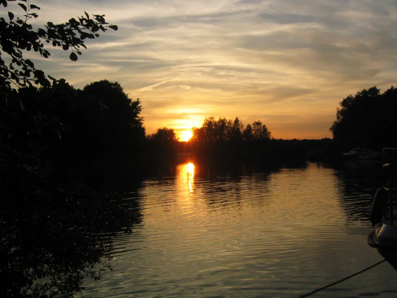 Sonnenuntergang über der Spree hinter den Uferbäumen